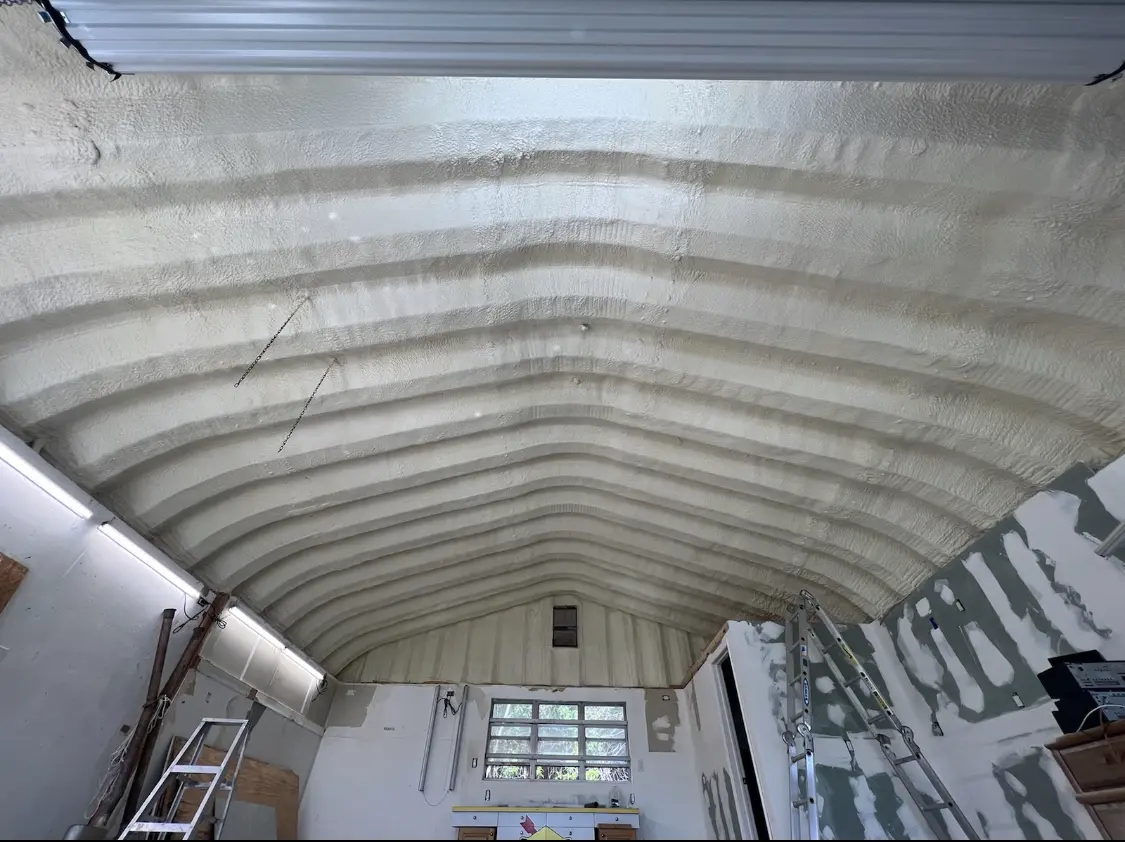 Spray polyurethane foam applied to the underside of a metal roof deck in Laurens